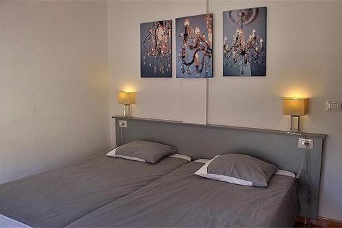 PuertoVV ATICO PUERTO TAZACORTE的一间卧室设有两张床,墙上有两盏灯。