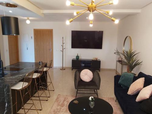 马拉喀什Luxueux appartement entre Gueliz et l'Hivernage avec WIFI的带沙发和酒吧的客厅