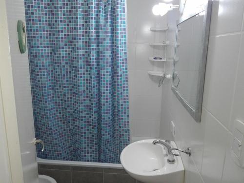 布兰卡港MONOambienteporDIA的浴室设有蓝色的浴帘和水槽