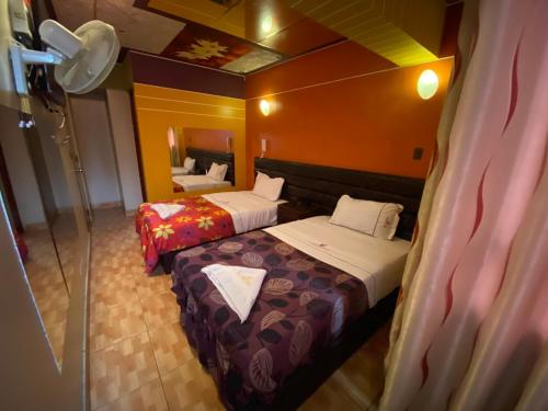 利马Hotel Manantial No,001的酒店客房,设有两张床和镜子