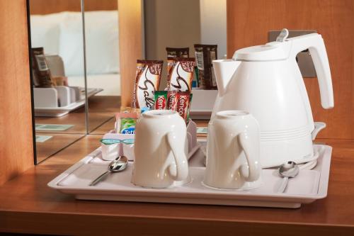 卡迪夫假日加的夫城市酒店的茶壶和盘子上的两个杯子