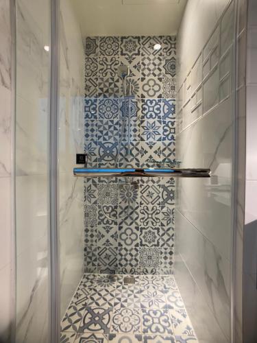大湖乡采莓行馆的浴室设有蓝色和白色瓷砖淋浴。