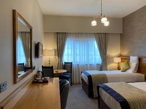 Burt安格里兰酒店的酒店客房设有两张床和一张桌子。