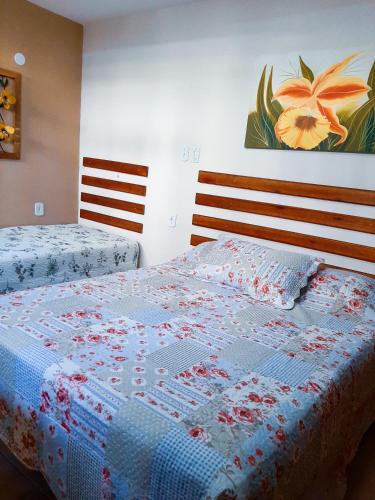 阿拉亚尔-杜卡布Suites Oliveira的一间卧室配有两张床,床上有被子