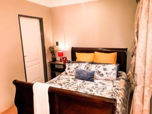 布隆方丹Quiet Getaway的一间卧室配有带橙色和蓝色枕头的床
