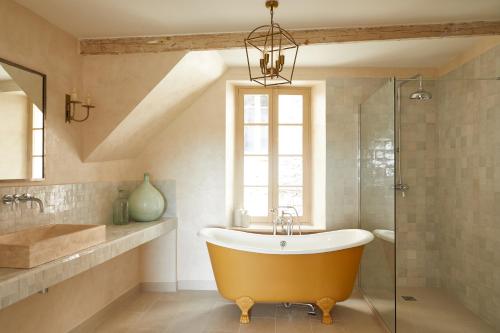 圣保罗-德旺斯Luxury townhouse in the heart of medieval St Paul de Vence的一间带大浴缸和窗户的浴室