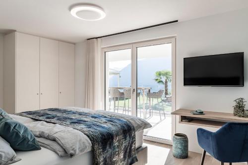 思科纳Romy & Johannes Guesthouse的一间卧室设有一张床、一台电视和一个阳台。