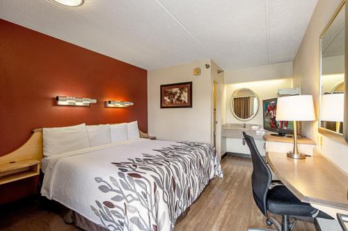 坎顿坎顿红屋顶酒店的配有一张床和一张书桌的酒店客房