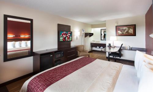 埃辛顿费城机场红屋顶PLUS+酒店的酒店客房设有一张大床和一张书桌。