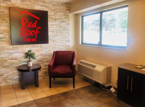 布里奇顿Red Roof Inn Bridgeton的一间设有红色岩石电视和椅子的等候室