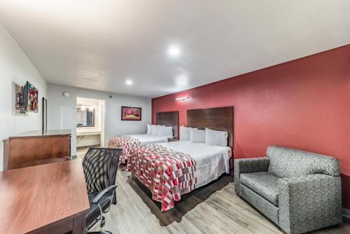 梅斯基特Red Roof Inn Dallas - Mesquite Fair Park NE的酒店客房,配有床、桌子和椅子