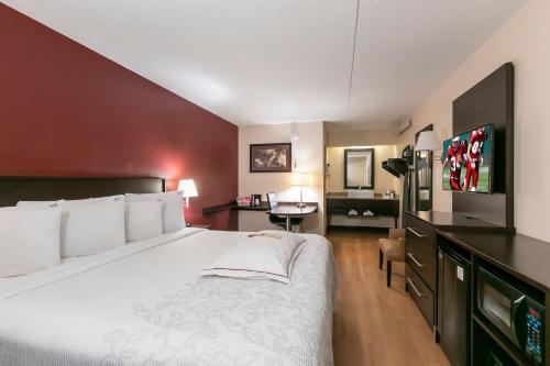 亚特兰大亚特兰大巴克黑德普拉斯加红屋顶酒店的酒店客房设有一张大床和一张书桌。