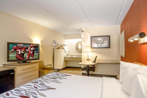 米尔福德米尔福德-纽黑文红屋顶客栈的配有一张床和一台平面电视的酒店客房
