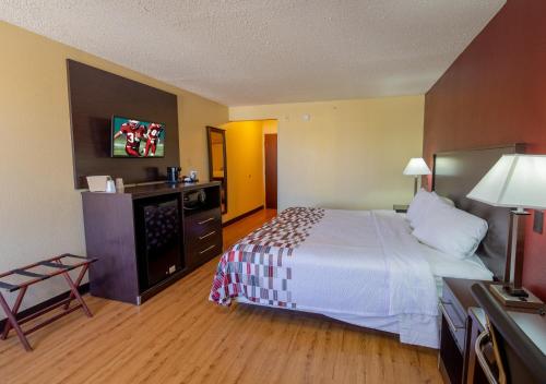 印第安纳波利斯印第安纳波利斯机场红屋顶套房客栈的酒店客房设有一张大床和一台电视。