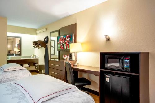 林夕昆高地Red Roof Inn PLUS+ Baltimore-Washington DC/BWI Airport的酒店客房设有一张床和一张带电视的书桌。