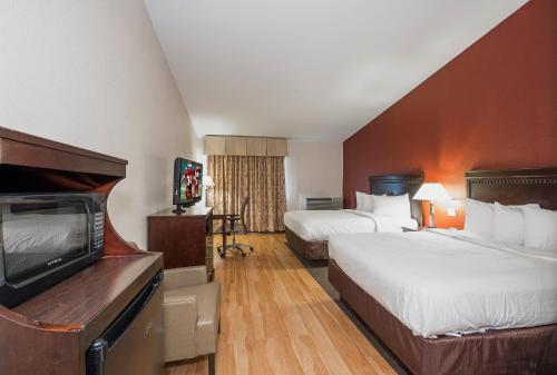 维斯坦顿城Red Roof Inn & Suites Mt Holly - McGuire AFB的酒店客房设有两张床和一台平面电视。