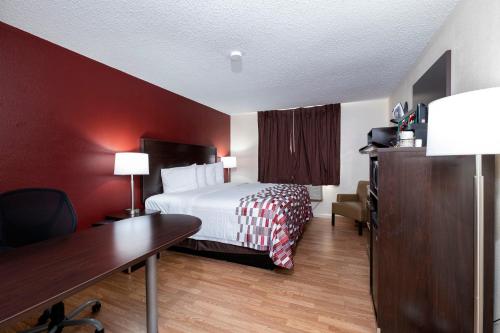 朴次茅斯Red Roof Inn Norfolk - Portsmouth的酒店客房配有一张床、一张书桌和一张书桌。