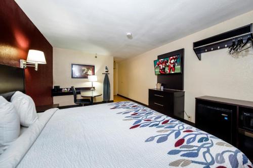 杰克逊维尔杰克逊维尔-邮轮港红顶屋酒店的配有一张床和一张书桌的酒店客房
