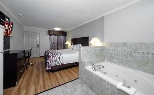 阿林顿Red Roof Inn Arlington - Entertainment District的酒店客房配有一张床和浴缸。