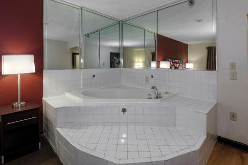 欧佩莱卡Red Roof Inn PLUS+ & Suites Opelika的大型白色浴缸及大镜子