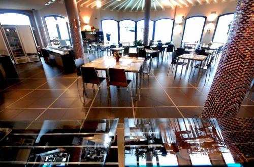 卡萨尔马焦雷艾尔伯格德莱尹杜斯特雷酒店的用餐室设有桌椅和窗户。