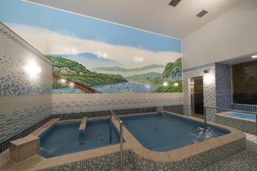 京都Umekoji Potel KYOTO的浴室设有热水浴缸,墙上有绘画作品