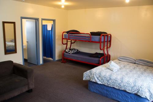 凯库拉The Lazy Shag Lodge的带两张双层床和椅子的房间