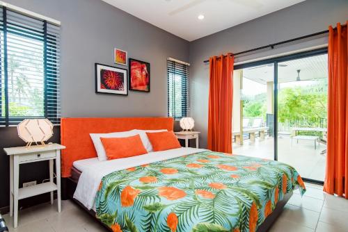 盼武里那普兰泳池别墅的一间卧室配有一张带橙色床罩的床