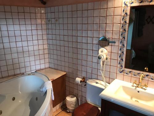 列斯Casa rural calRei的带浴缸、水槽和镜子的浴室