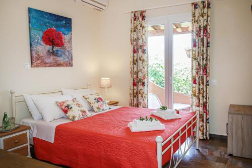 阿查拉维Navigator Villas - Houses的一间卧室配有一张带红色毯子的床和窗户。