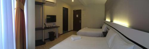 瓜拉雪兰戈Grand Kapar Hotel Kuala Selangor的酒店客房,配有床和电视