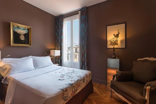 米兰帕蒂尼宾馆的卧室配有床、椅子和窗户。