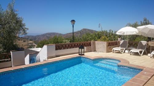弗里希利亚纳Casa Rural Las Molina的游泳池旁设有椅子和遮阳伞