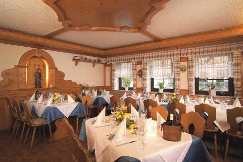 纽伦堡Landgasthof Hotel Grüner Baum的用餐室配有桌椅和白色桌布