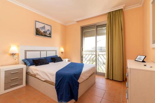 格拉纳迪利亚德亚沃纳HomeForGuest Spacious and bright flat on the beach La Tejita的一间卧室设有一张床和一个大窗户