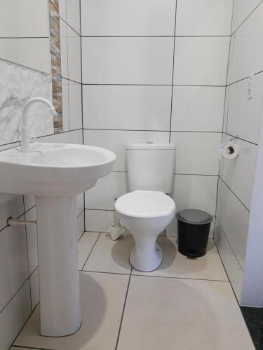 帕尔马斯Pousada Braga的白色的浴室设有卫生间和水槽。