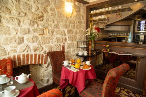 巴黎Hotel Du Beaumont的一间设有桌子和石墙的用餐室