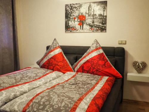 腓特烈罗达Dorfidylle - Thüringer Wald Rennsteig的一间卧室配有一张带红色和灰色枕头的床