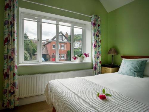 彻奇斯特雷顿Magnolia Cottage的一间卧室配有一张带白色床罩的床和窗户。