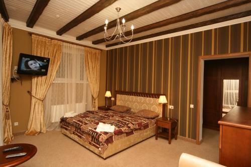 亚列姆切奥沙勒酒店的一间卧室配有一张床和一个吊灯
