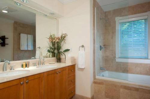 The Bight SettlementsVilla Renaissance Unit 501 Grace Bay Beach的带浴缸、水槽和镜子的浴室