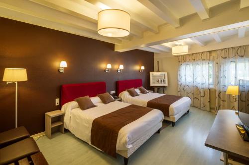 圣克洛德圣休伯特酒店的酒店客房设有两张床和一张桌子。