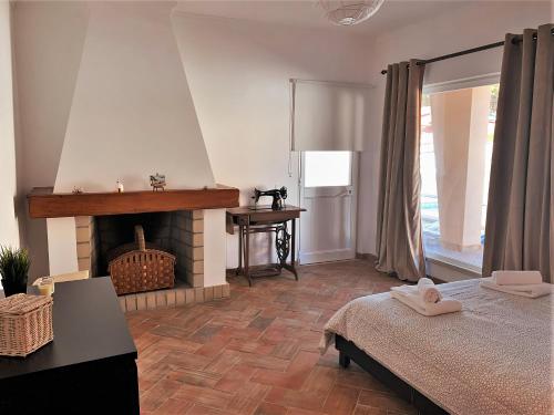 克洛伊奥斯Moradia Pinhal da Telha的一间卧室配有一张床和一个壁炉