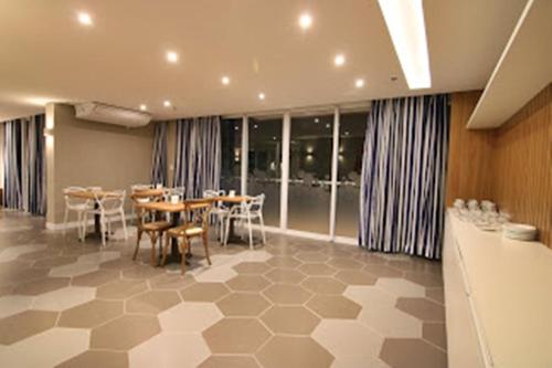 卡波布里奥Flat Edifício Royale 305的用餐室设有桌椅和窗户。