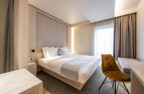 鲁汶贝居安会酒店的配有一张床和一张书桌的酒店客房
