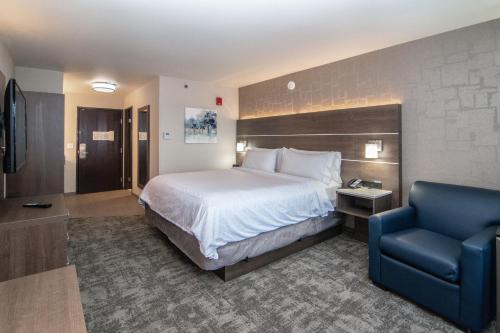斯波坎斯波坎 - 市区智选假日酒店的酒店客房,配有一张床和一张蓝色椅子