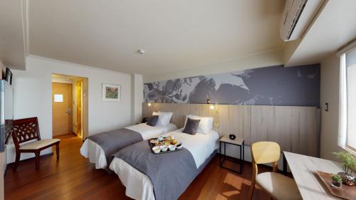 圣地亚哥Hotel Brasilia的酒店客房设有两张床和一张桌子。