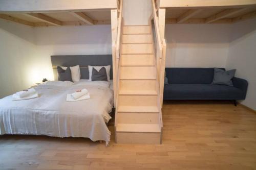 因斯布鲁克Cosy and Spacious Apartment in the heart of Innsbruck的一间卧室设有一张床、一个楼梯和一张沙发