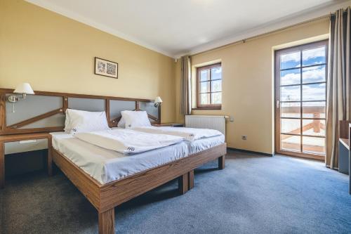 Dolní VltaviceHotel Resort Relax的一间卧室配有一张带白色床单的大床