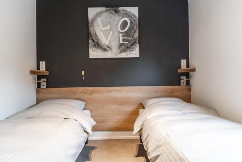 卡兰茨奥赫New Bay的卧室设有两张床,拥有黑色的墙壁